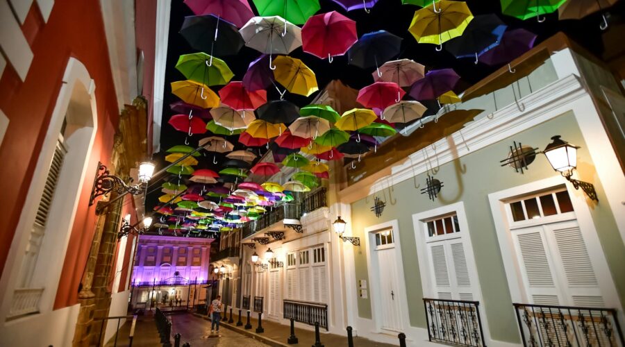 assorted coloured umbrellas hanging near buildings